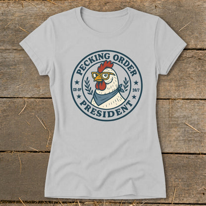 Light grey t-shirt with a circular graphic of a chicken wearing glasses and bandana, reading "Pecking Order President".