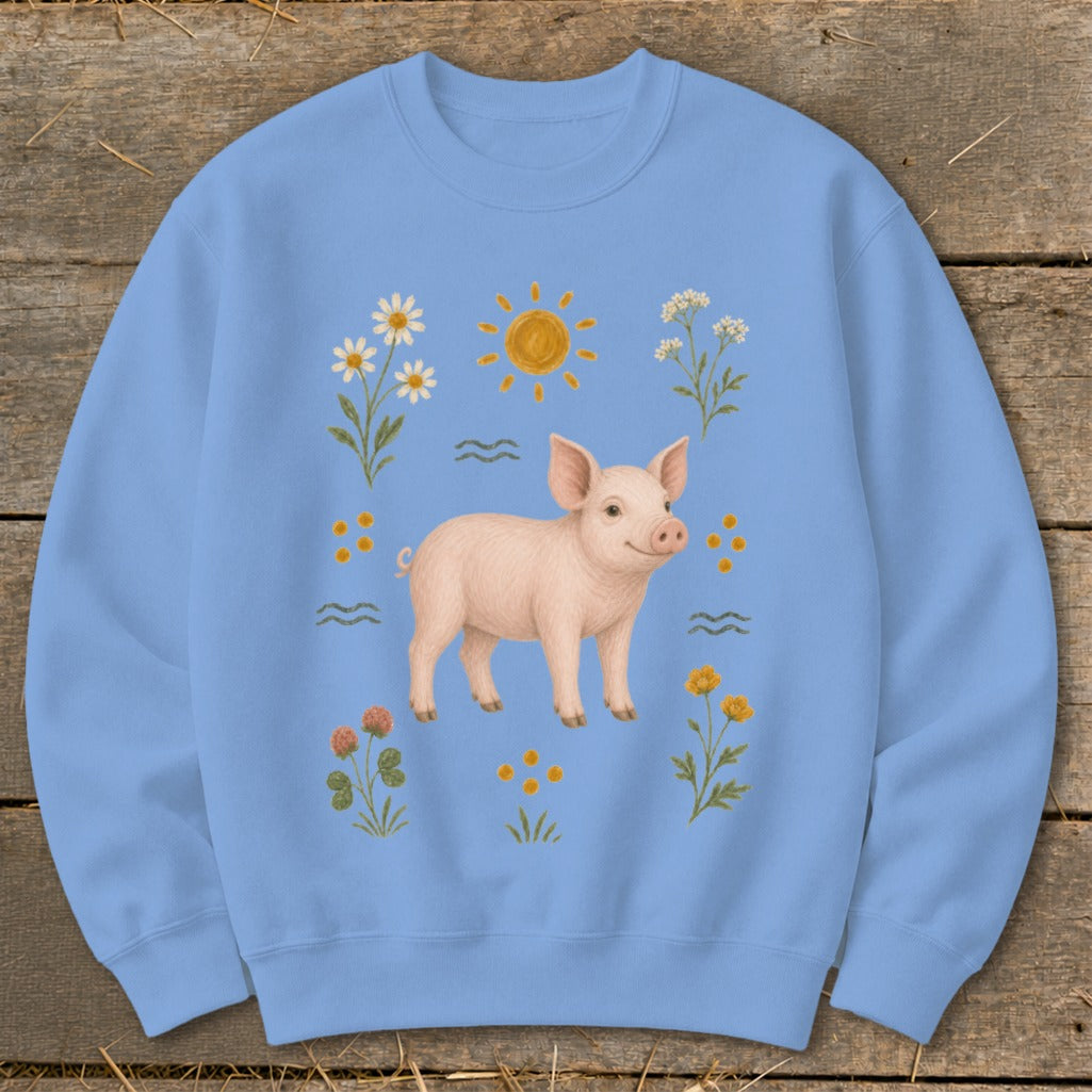 Light blue sweatshirt with a pink pig surrounded by flowers, sun, and wavy lines.