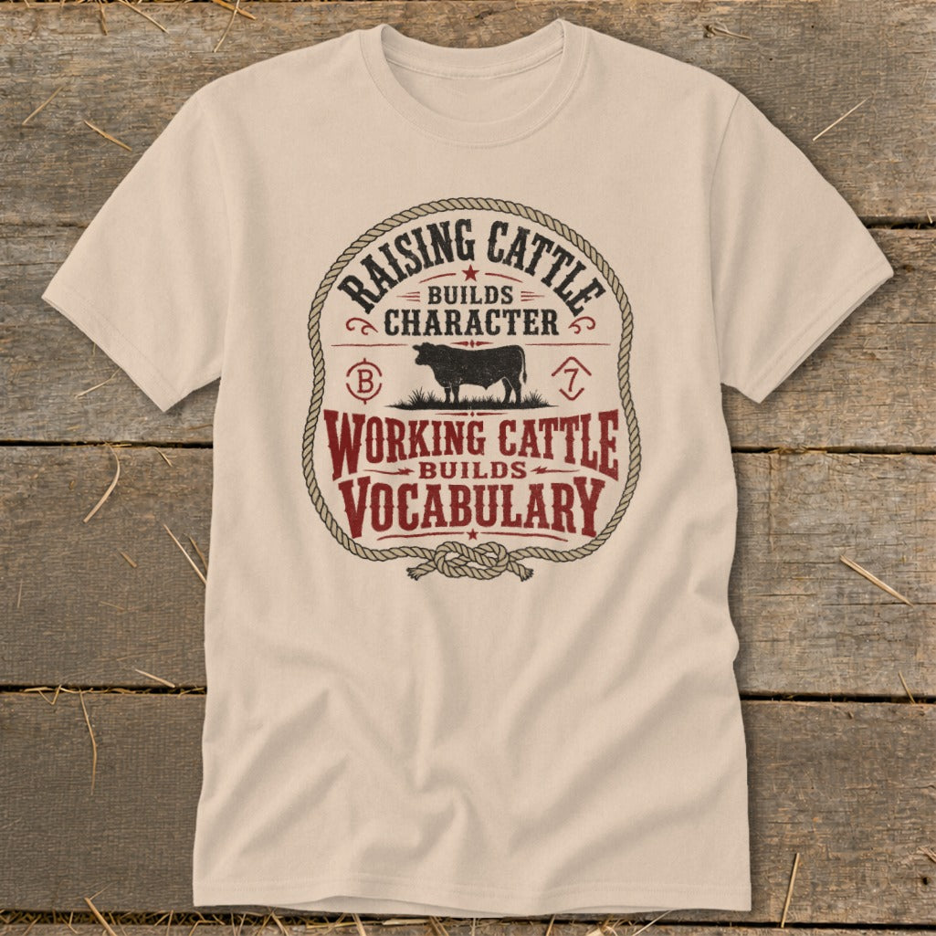 Beige t-shirt with graphic "Raising Cattle Builds Character, Working Cattle Builds Vocabulary" and a cow.