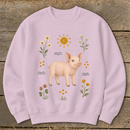 Pink sweatshirt with a watercolor illustration of a pig surrounded by flowers and a sun.
