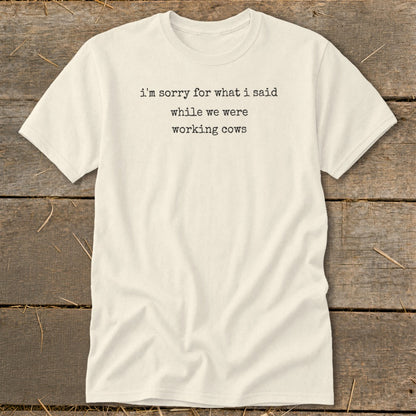Cream t-shirt with black text reading "i'm sorry for what i said while we were working cows."