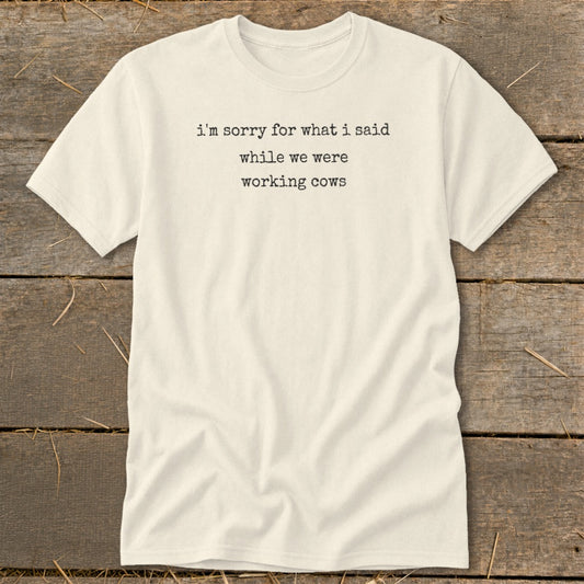 Cream t-shirt with black text reading "i'm sorry for what i said while we were working cows."