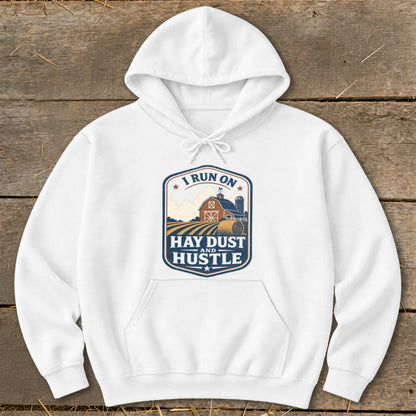 White hoodie with "I RUN ON HAY DUST AND HUSTLE" farm graphic on chest.