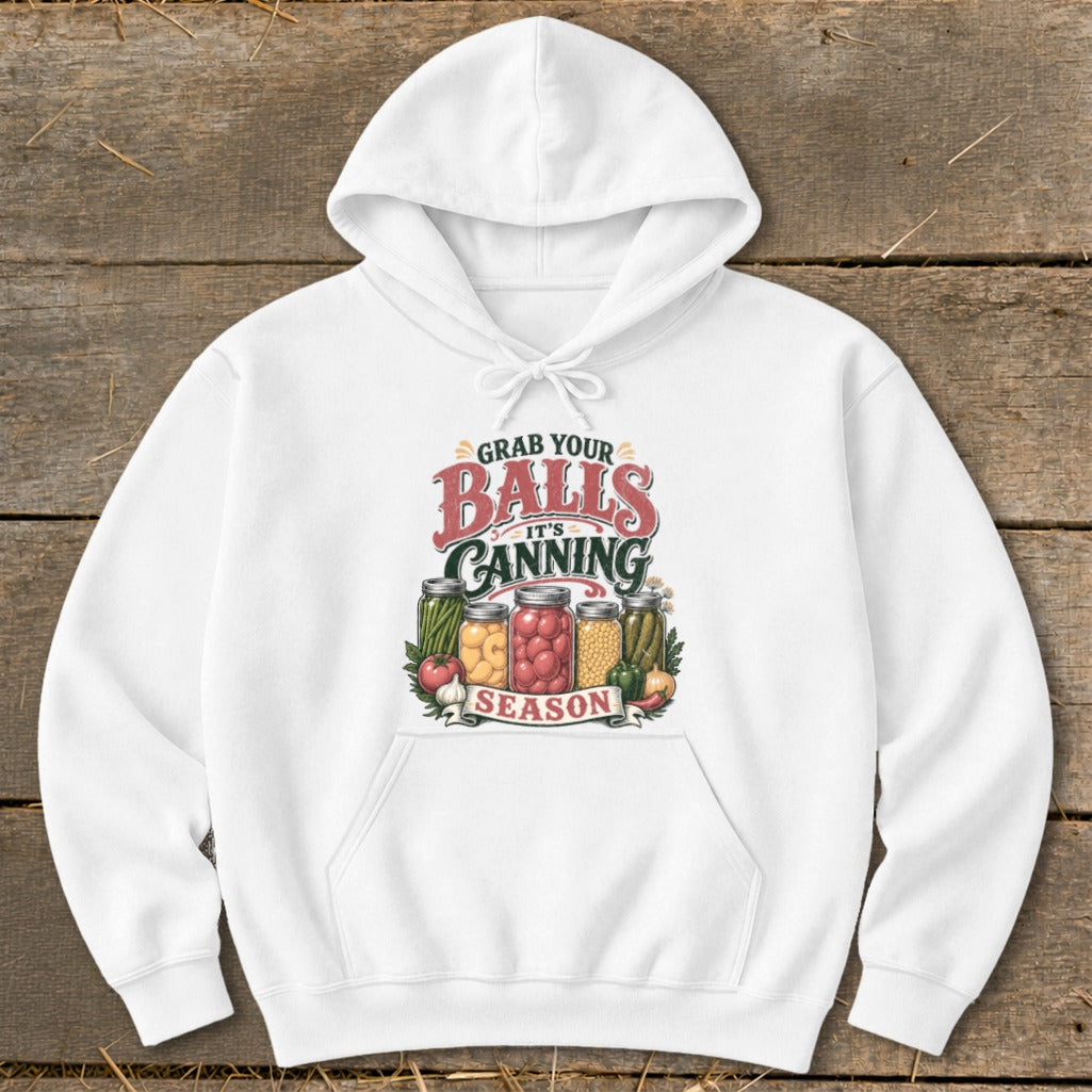 White hoodie with "Grab Your Balls It's Canning Season" text and jars of preserved vegetables.