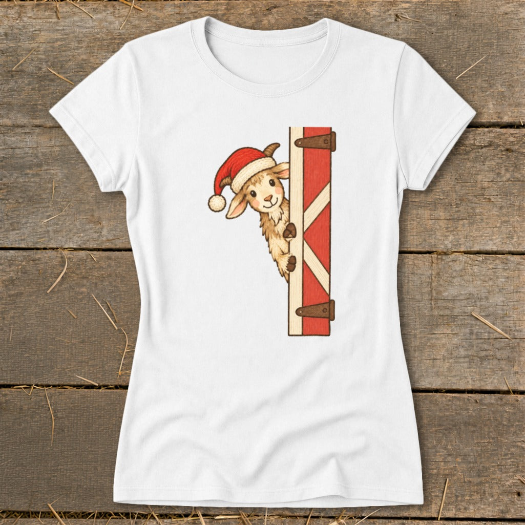 Goat wearing a Santa hat peeks from behind a red barn door.