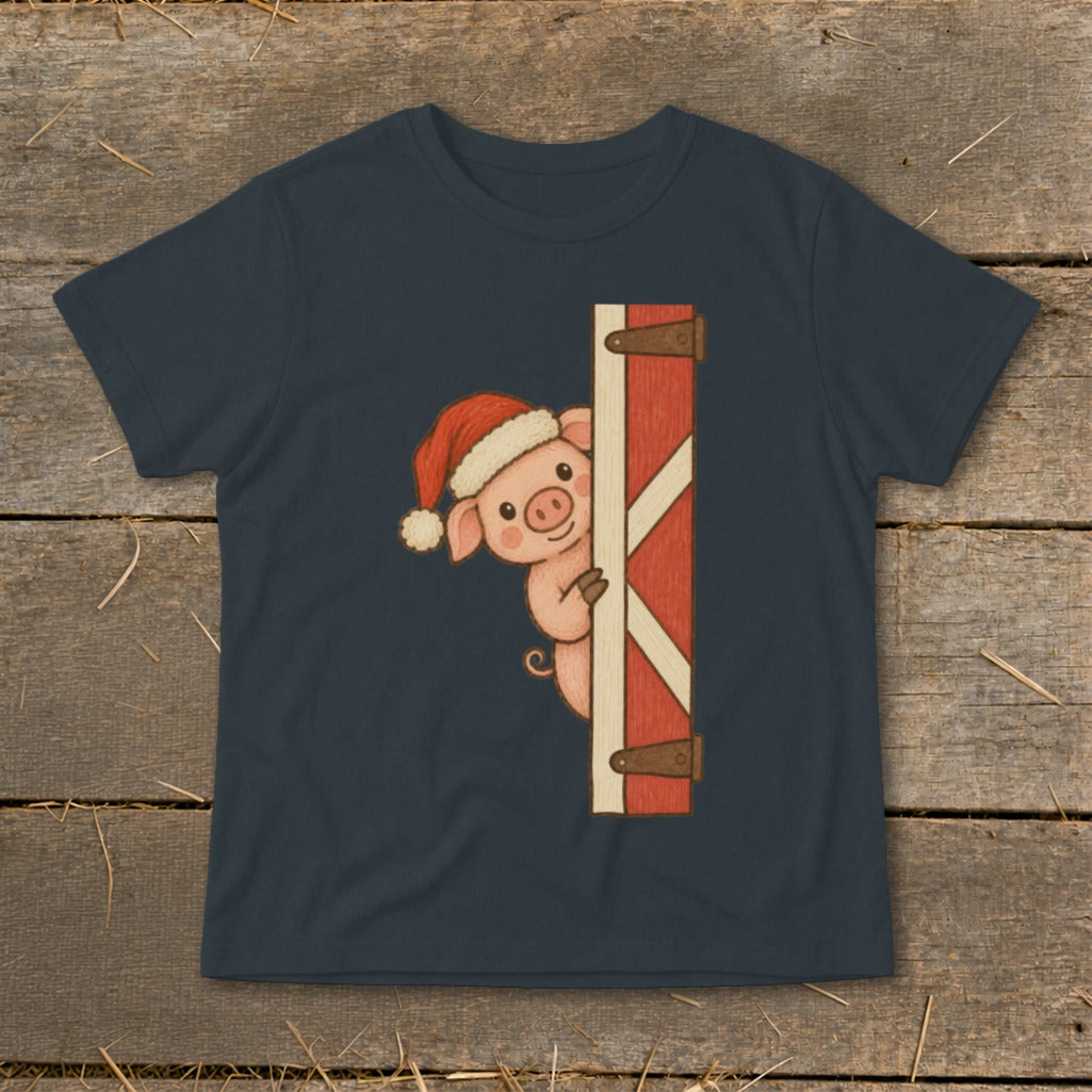 Pig wearing Santa hat peeking from behind a barn door graphic on a dark blue t-shirt.