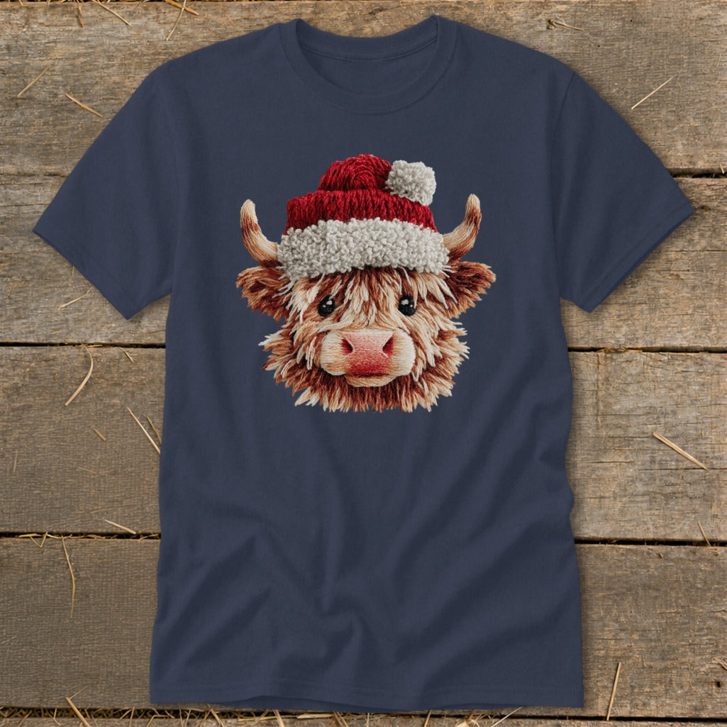Fluffy Highland cow wearing a Santa hat on a navy blue t-shirt.