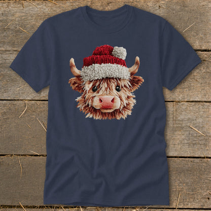 Fluffy Highland cow wearing a Santa hat on a navy blue t-shirt.