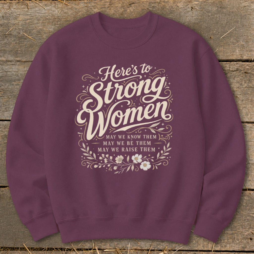 Maroon sweatshirt with text "Here's to Strong Women. May we know them, may we be them, may we raise them."