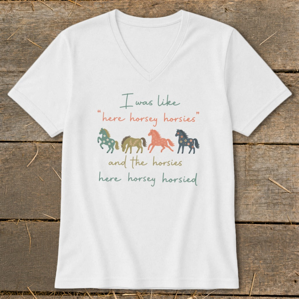 White v-neck t-shirt with colorful horses and text: "I was like 'here horsey horsies' and the horsies here horsey horsied"