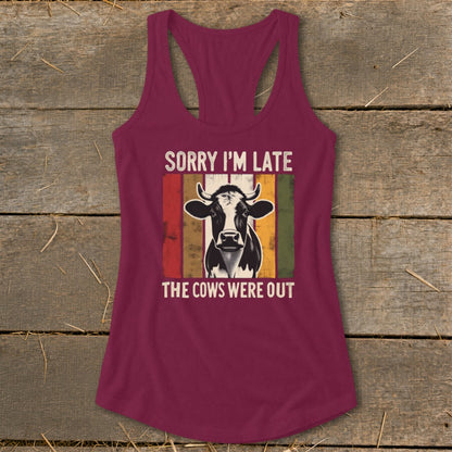 Burgundy tank top with a cow graphic and text "SORRY I'M LATE THE COWS WERE OUT".