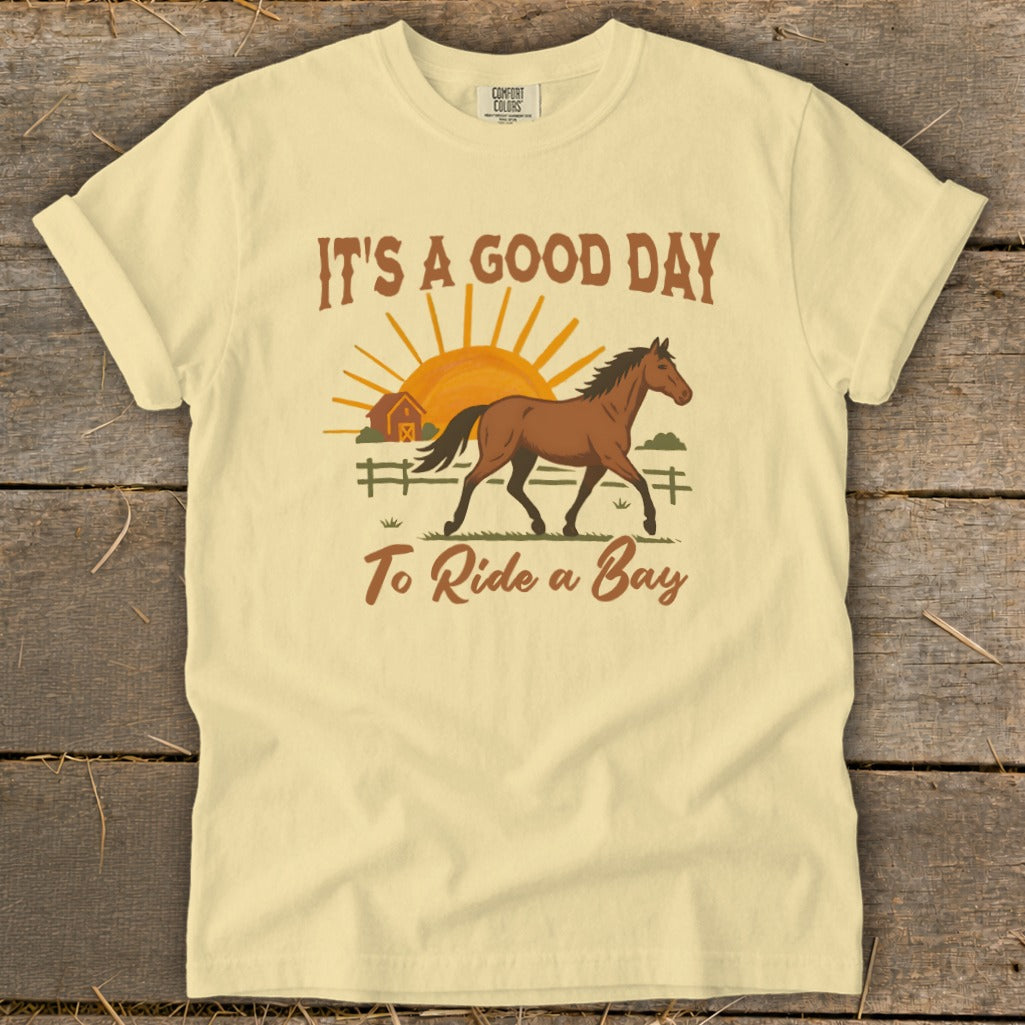 Yellow t-shirt with a graphic of a brown horse, barn, sun, and text "IT'S A GOOD DAY To Ride a Bay".