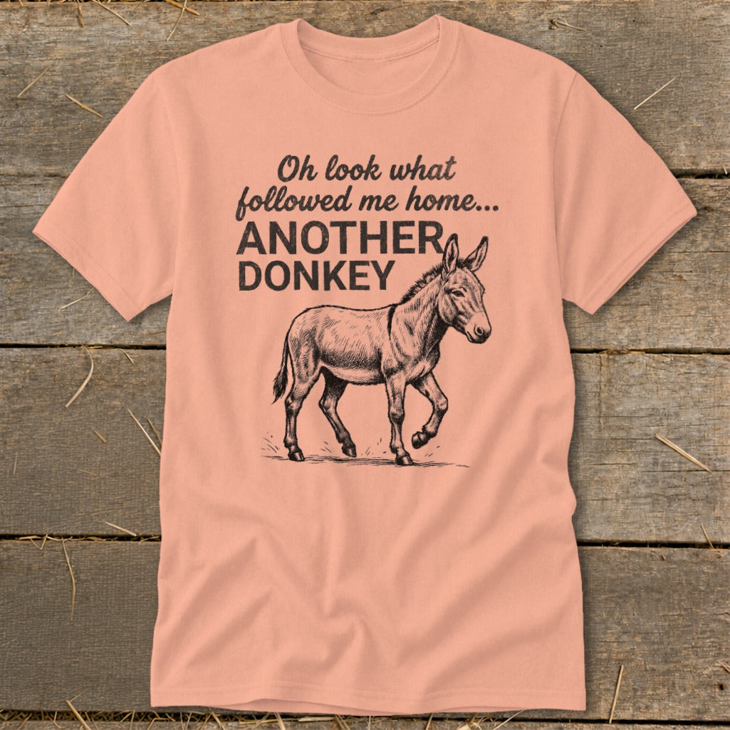Peach t-shirt with sketch of a walking donkey and text: "Oh look what followed me home... ANOTHER DONKEY"