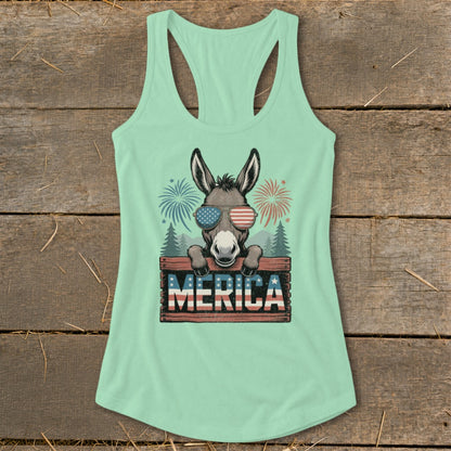 Donkey wearing American flag sunglasses behind "Merica" sign with fireworks.