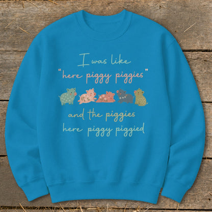 Blue sweatshirt with text "I was like 'here piggy piggies' and the piggies here piggy piggyed" and cartoon pigs.