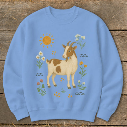 Light blue sweatshirt with a brown and white goat surrounded by flowers and a sun.