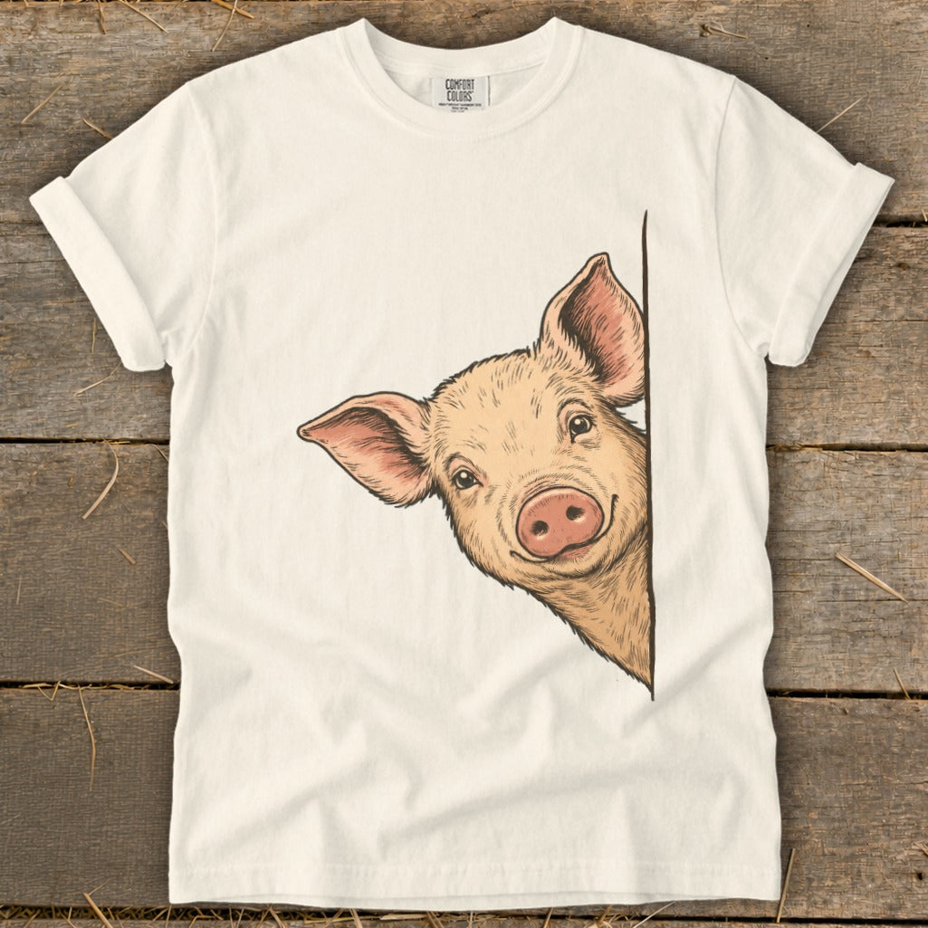 White t-shirt with a peeking pig illustration.