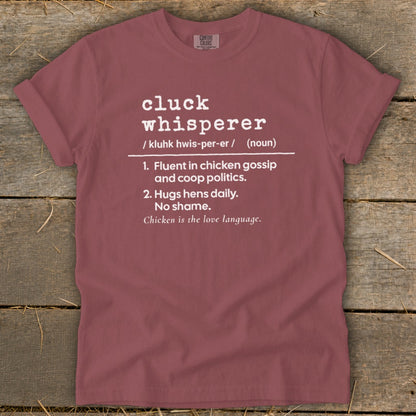 Maroon t-shirt with "Cluck Whisperer" definition printed in white.