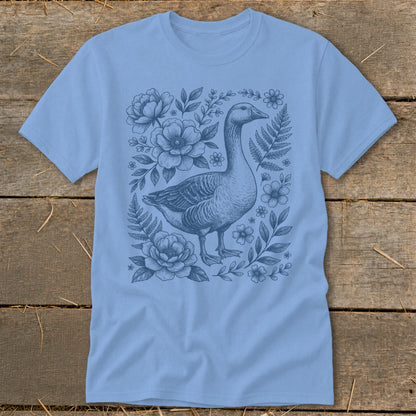 Light blue t-shirt with a blue ink illustration of a goose surrounded by flowers and ferns.