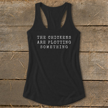 Black racerback tank top with white text reading "THE CHICKENS ARE PLOTTING SOMETHING".