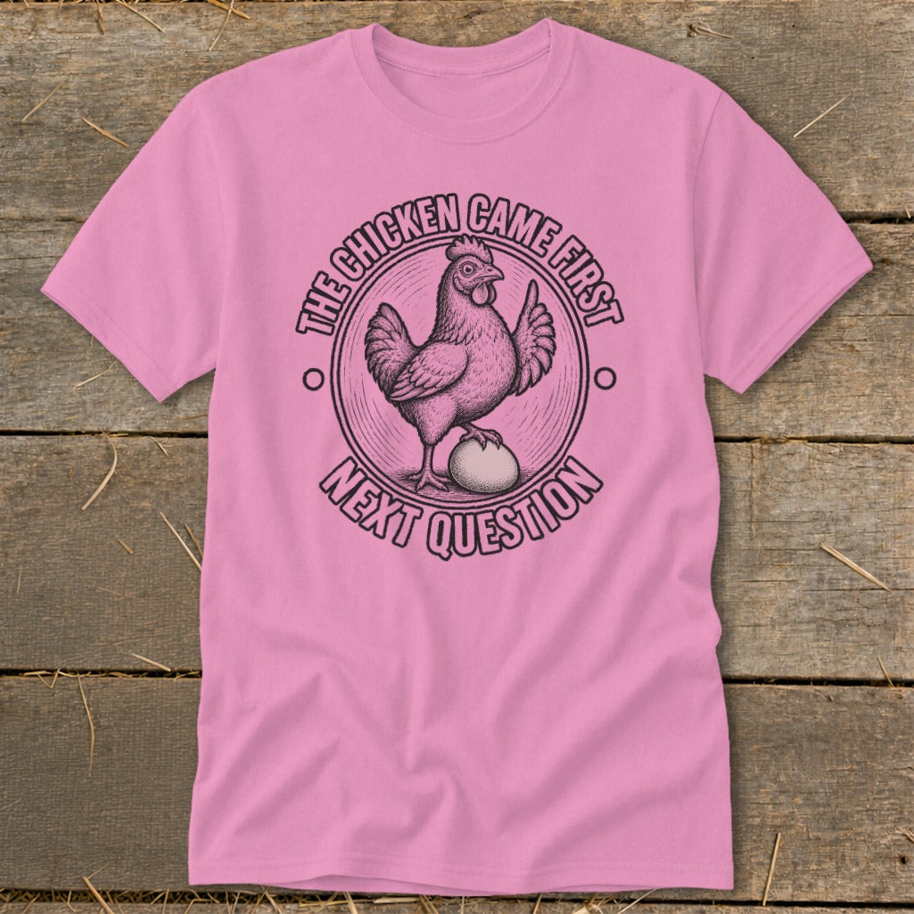 Pink t-shirt with illustration of chicken on egg, text "The chicken came first" and "Next question".