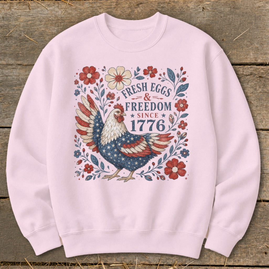 Pink sweatshirt with a patriotic chicken graphic and text "Fresh Eggs & Freedom Since 1776."