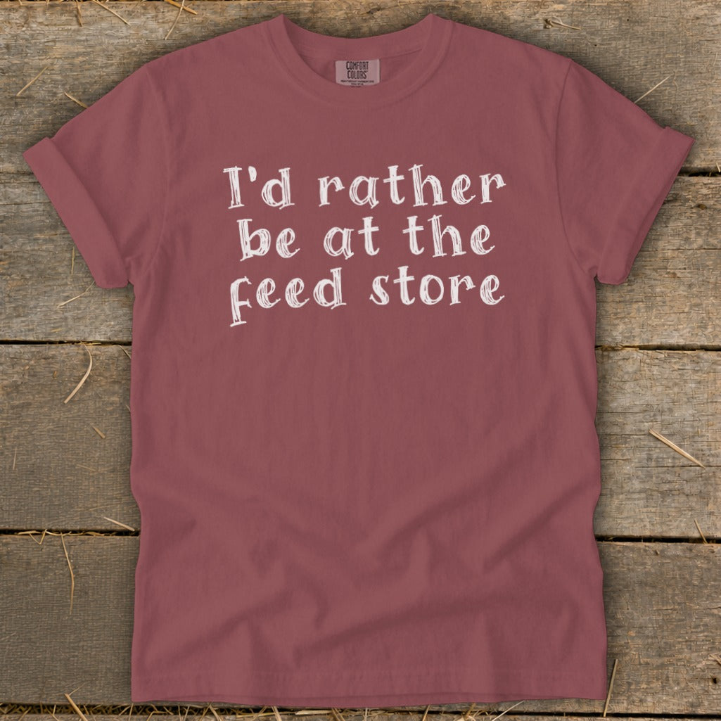 Maroon t-shirt with white text: "I'd rather be at the feed store."