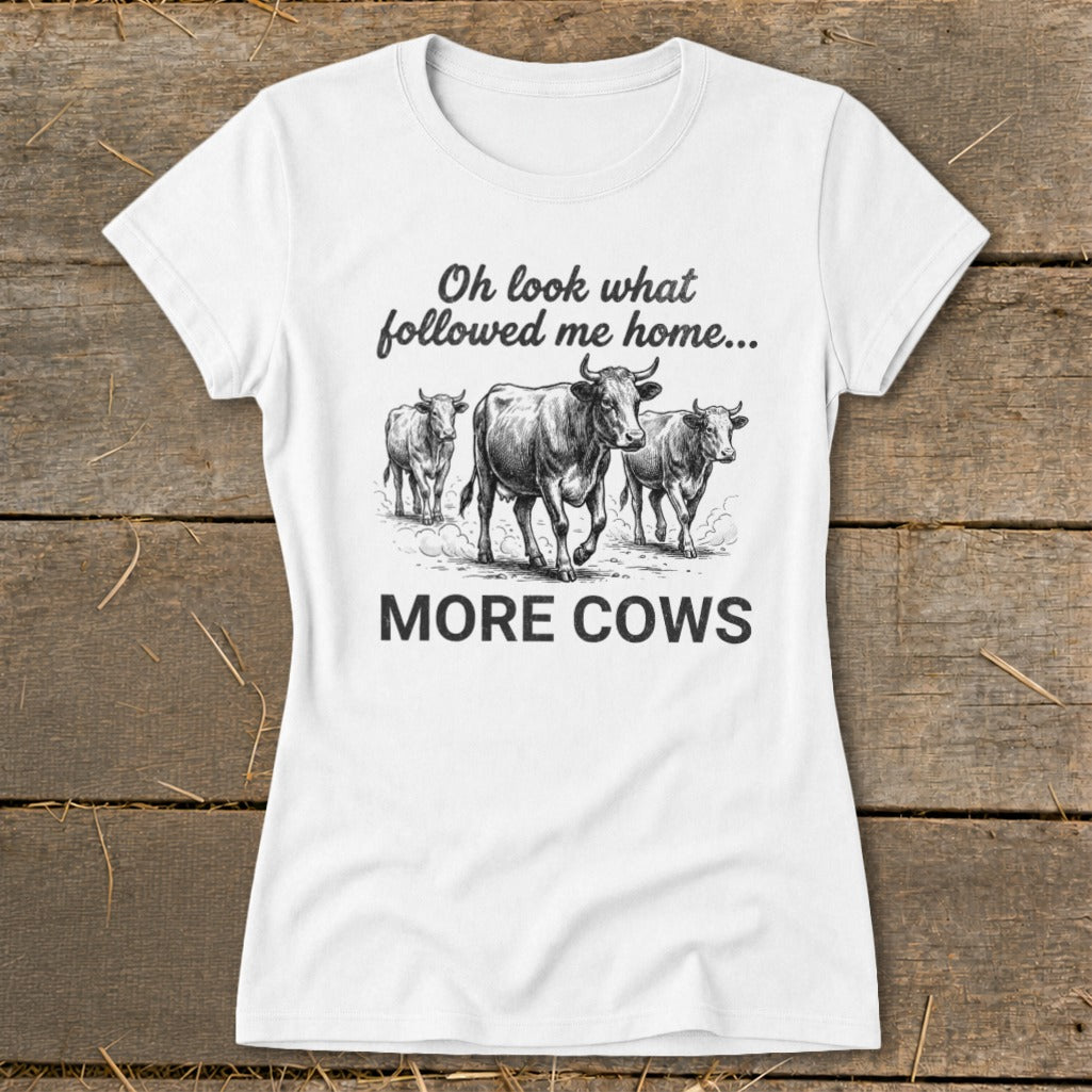 White t-shirt with illustration of three cows and text: "Oh look what followed me home... MORE COWS"