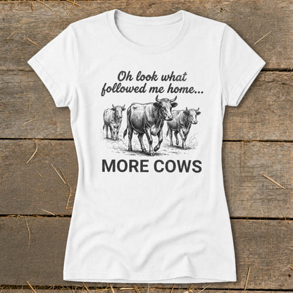 White t-shirt with illustration of three cows and text: "Oh look what followed me home... MORE COWS"