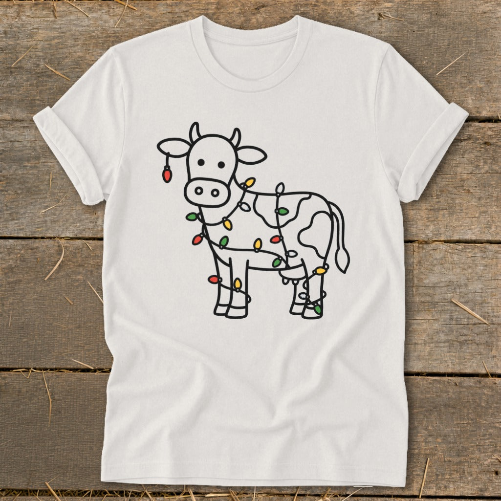 White t-shirt with line drawing of cow wrapped in colorful Christmas lights.