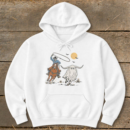 Cowboy skeleton on horse lassos a ghost longhorn under a full moon.