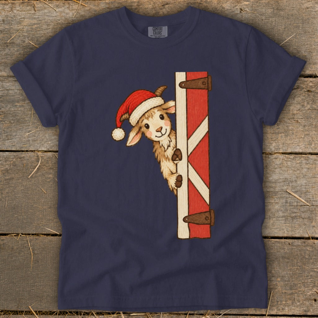 Navy t-shirt with a drawing of a goat in a Santa hat peeking around a barn door.