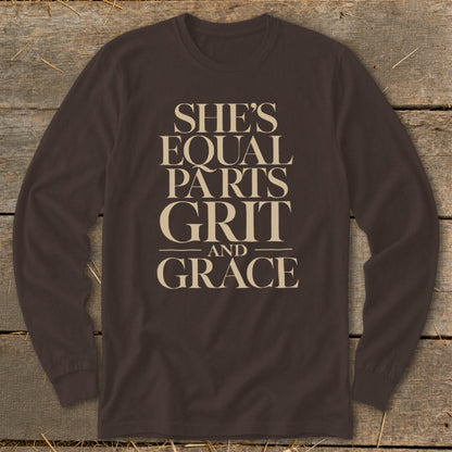 Brown long-sleeve shirt with text "SHE'S EQUAL PARTS GRIT AND GRACE".