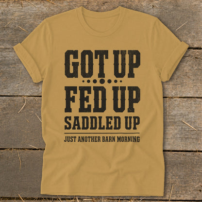 Gold t-shirt with black text: "GOT UP FED UP SADDLED UP JUST ANOTHER BARN MORNING"
