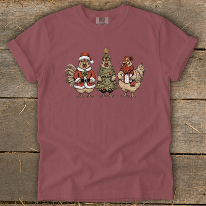 Rooster in Santa suit, chicken dressed as Christmas tree, and chicken with gift.