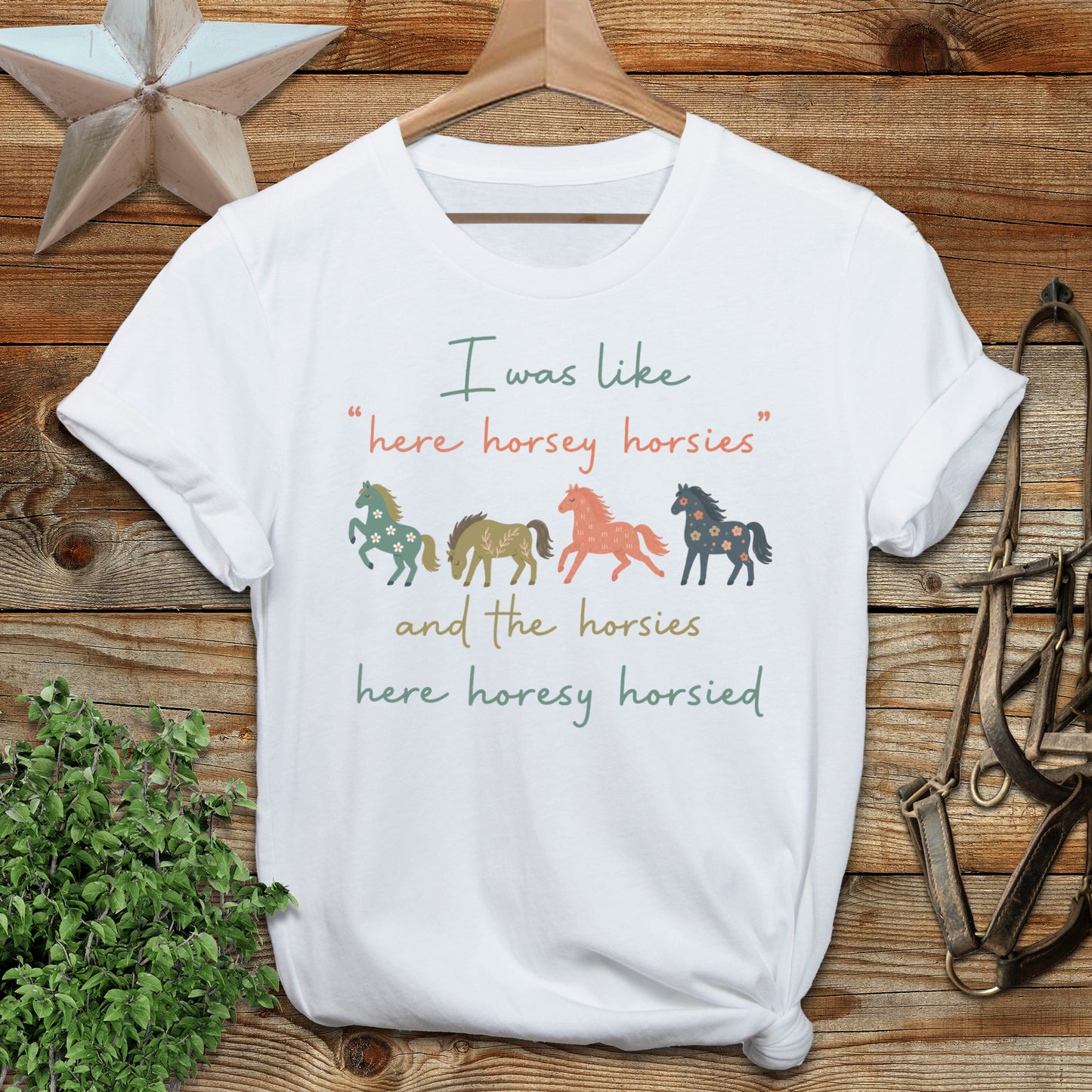White t-shirt with "here horsey horsies" text and floral horse graphics.