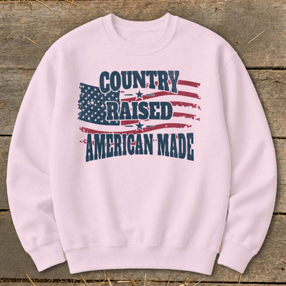 Pink sweatshirt with distressed American flag graphic and text: Country Raised American Made.