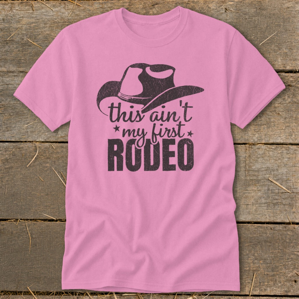 Pink t-shirt with cowboy hat graphic and text "this ain't *my first* RODEO"