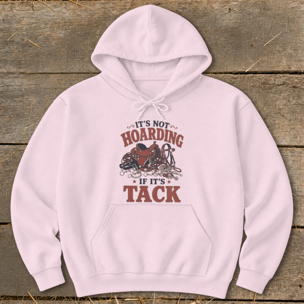 Light pink hoodie with "It's Not Hoarding If It's Tack" graphic featuring equestrian gear.