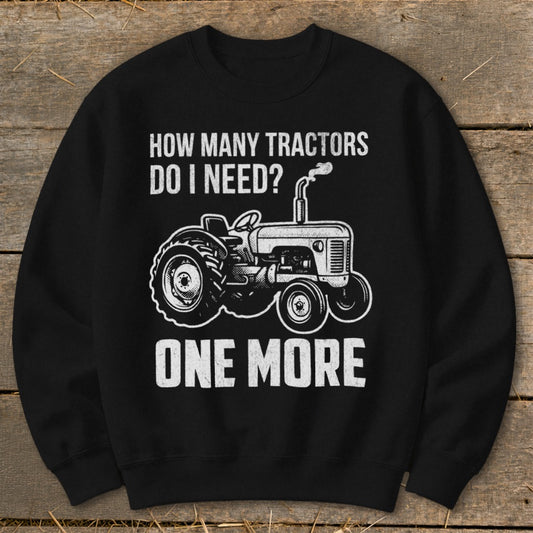 Black sweatshirt with white text and tractor graphic: "How many tractors do I need? One more."