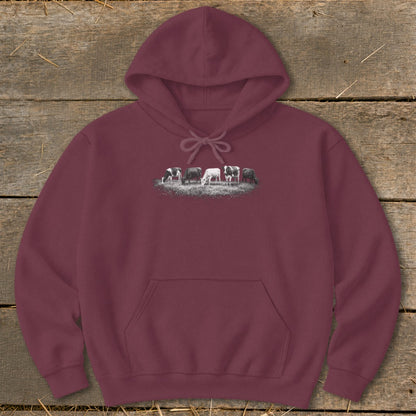 Maroon hoodie with a graphic of five cows grazing in a field.