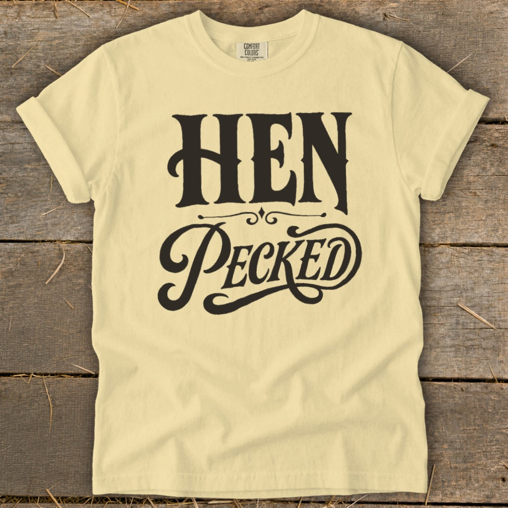 Yellow t-shirt with black text that reads "HEN PECKED" in decorative font.