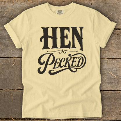 Yellow t-shirt with black text that reads "HEN PECKED" in decorative font.