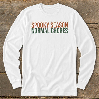 White long-sleeve shirt with text "SPOOKY SEASON NORMAL CHORES".