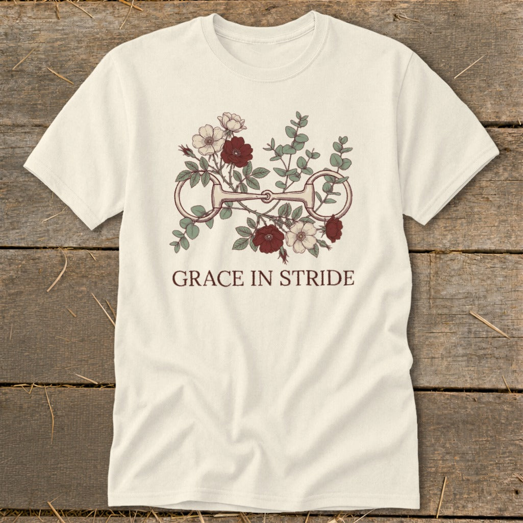 Cream t-shirt with a horse bit and floral design, reading "GRACE IN STRIDE".