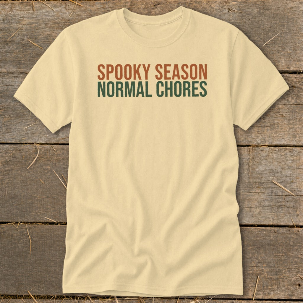 Cream t-shirt with "Spooky Season Normal Chores" text in rust and green.