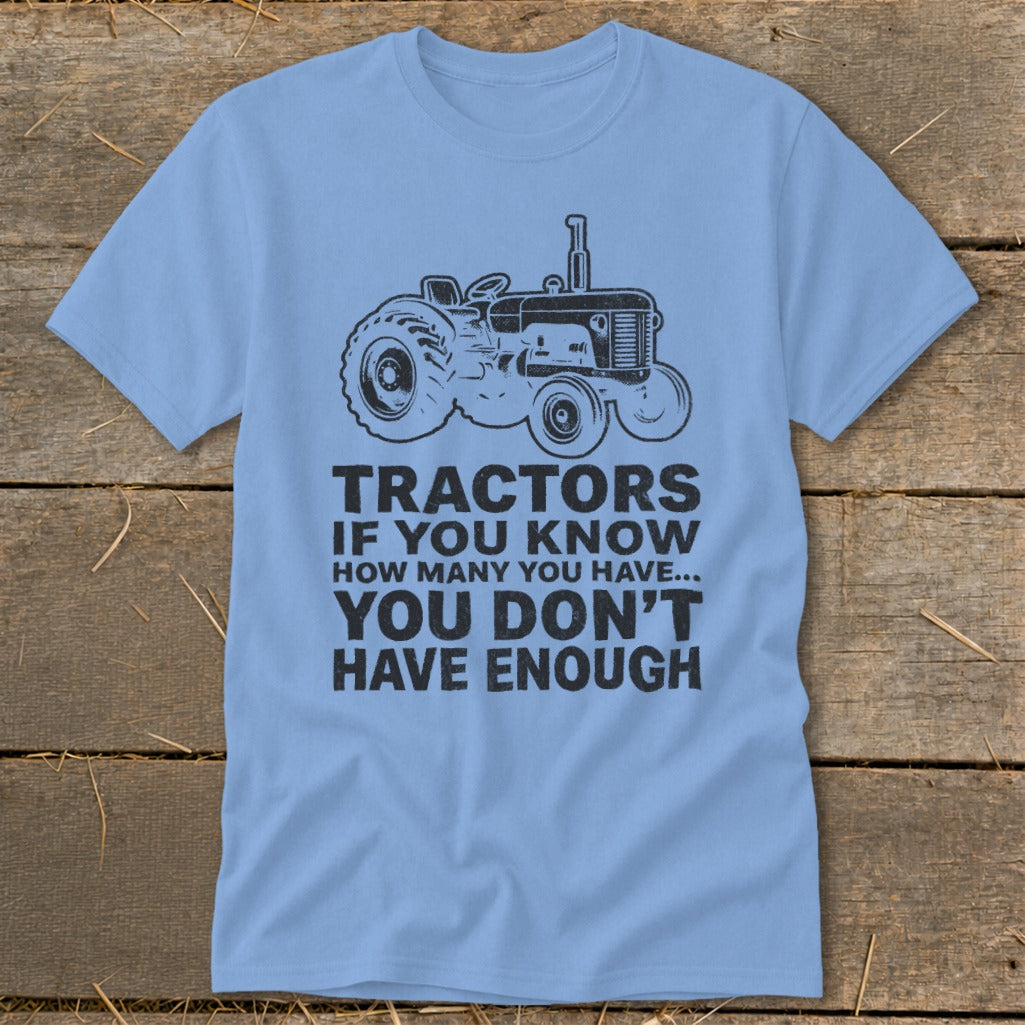 Light blue t-shirt with a black tractor graphic and text that reads "TRACTORS IF YOU KNOW HOW MANY YOU HAVE... YOU DON'T HAVE ENOUGH".