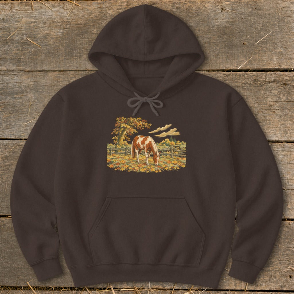 Brown hoodie with a painted horse grazing in a field of autumn leaves.