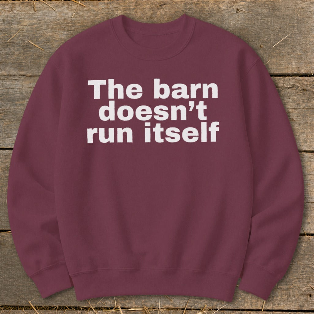 Maroon sweatshirt with white text reading "The barn doesn't run itself."