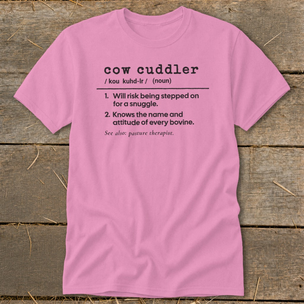 Pink t-shirt with "cow cuddler" definition: 1. Will risk being stepped on for a snuggle. 2. Knows the name and attitude of every bovine.